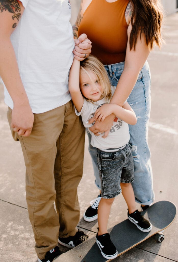 Austin Family Photographer, little child on skateboard with mother and father's hands on them
