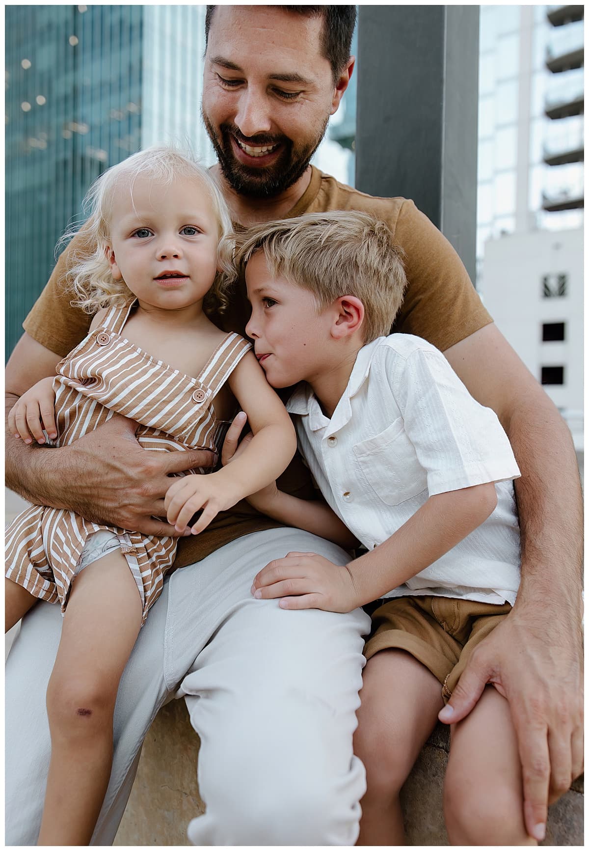 Dad holds young kids close together for Downtown Austin Rooftop Family Session 
