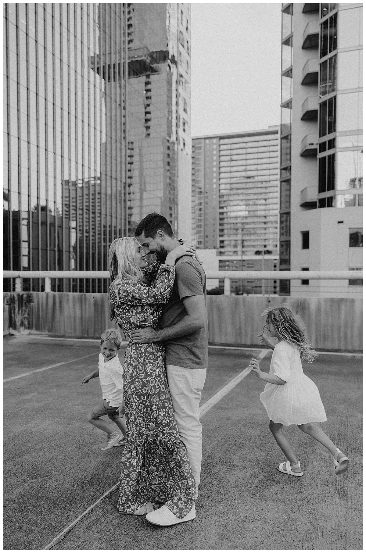 Mom and dad kiss for Downtown Austin Rooftop Family Session 