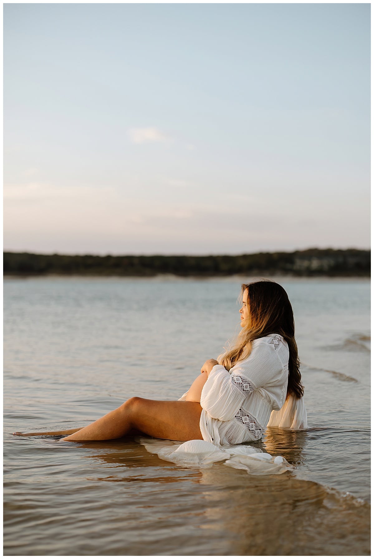 Woman embraces pregnant belly for Sandy Beach Maternity Session