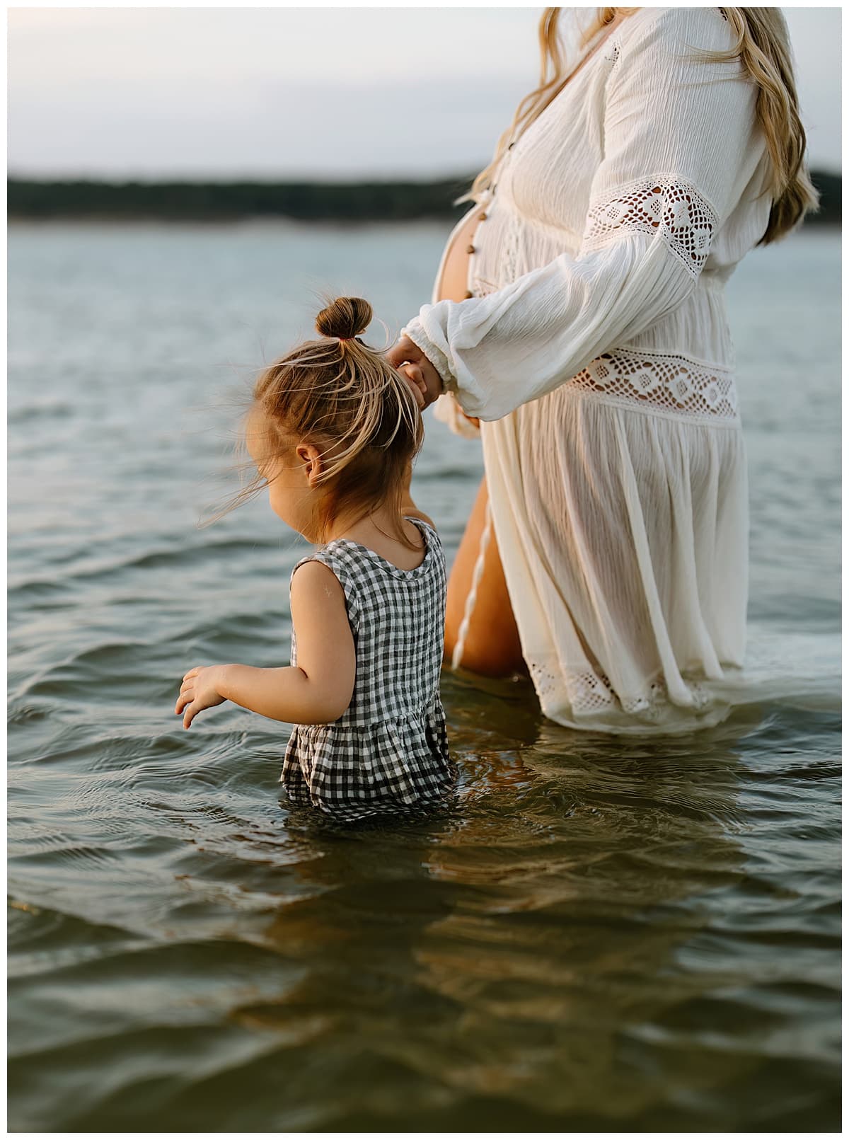 Mom and daughter walk together in the water for Sandy Beach Maternity Session