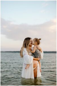 Mom and daughter hold each other close for Sandy Beach Maternity Session