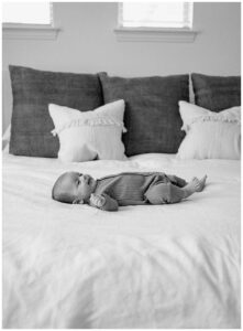 After Preparing For Your Newborn Storytelling Session Baby lays on the bed
