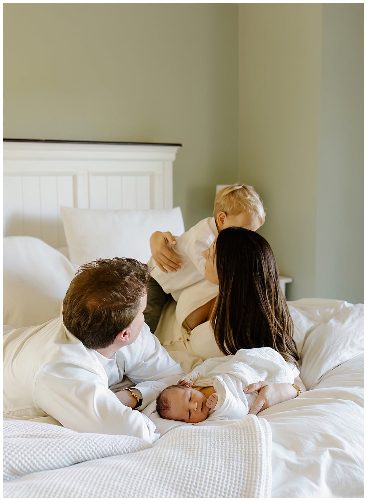 Family plays on the bed to Create Memories during their Newborn Storytelling Session