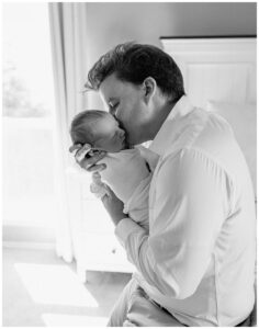 Dad shares a kiss with newborn for Austin Lifestyle Photographer