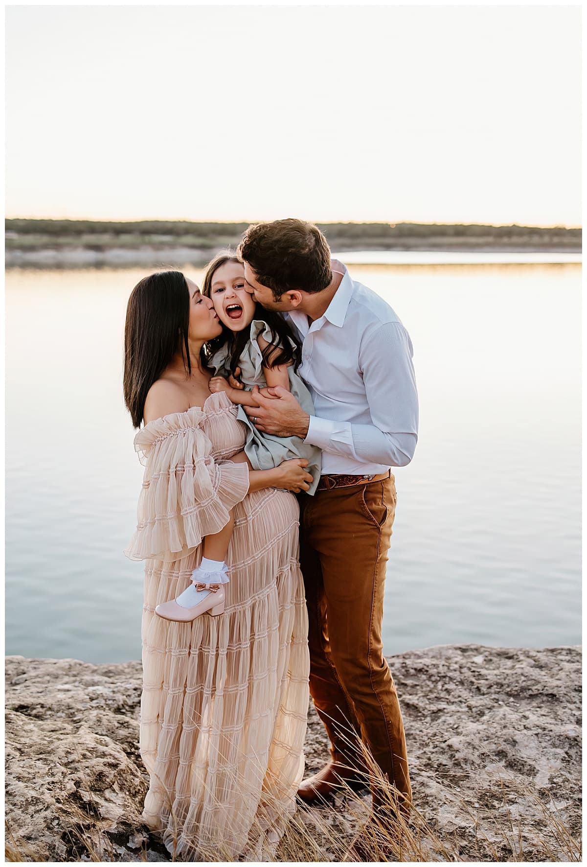 Parents kiss their daughter for outdoor lifestyle photoshoot
