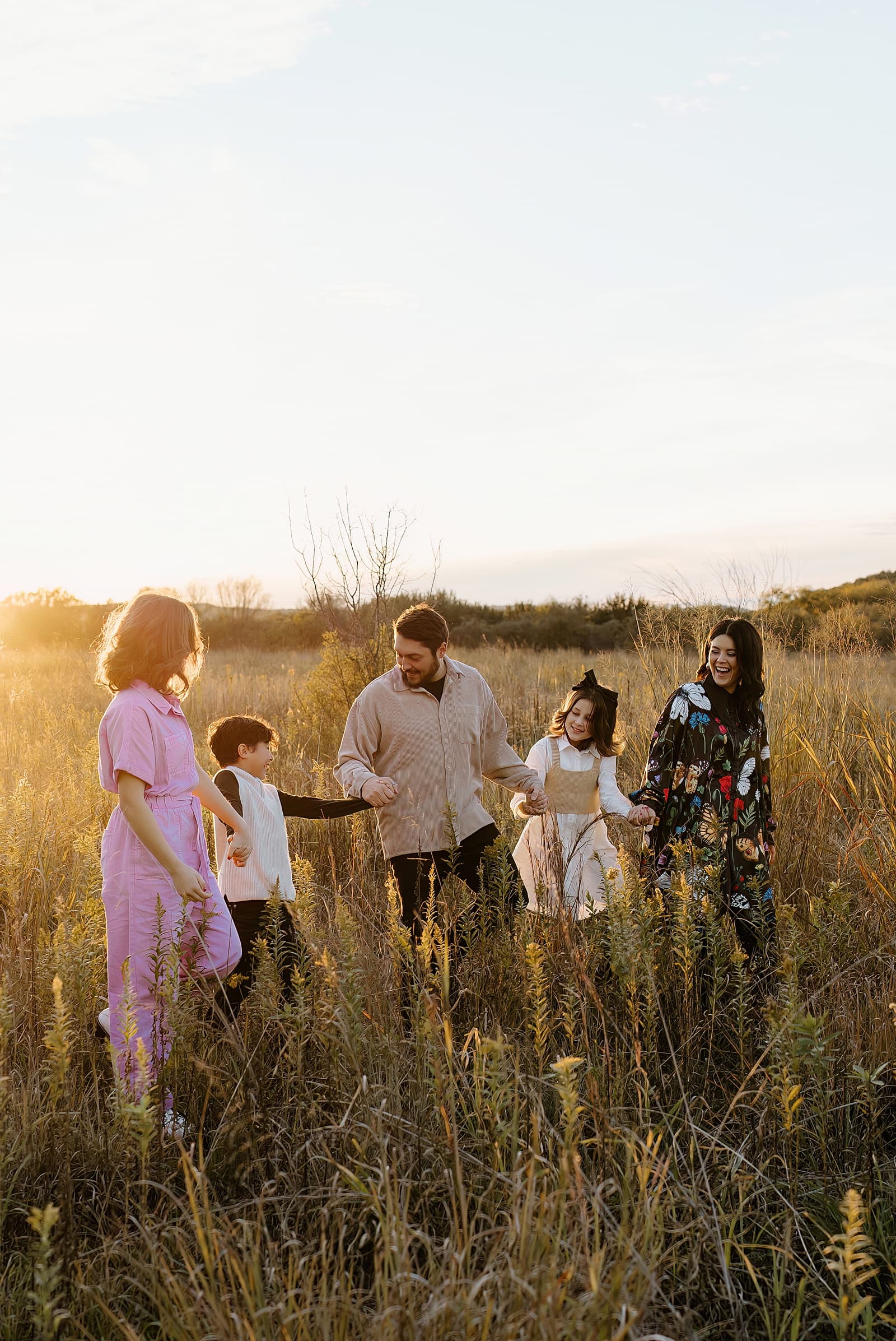Family walk together in field showing off the best Colorful Family Photo Outfit Inspiration