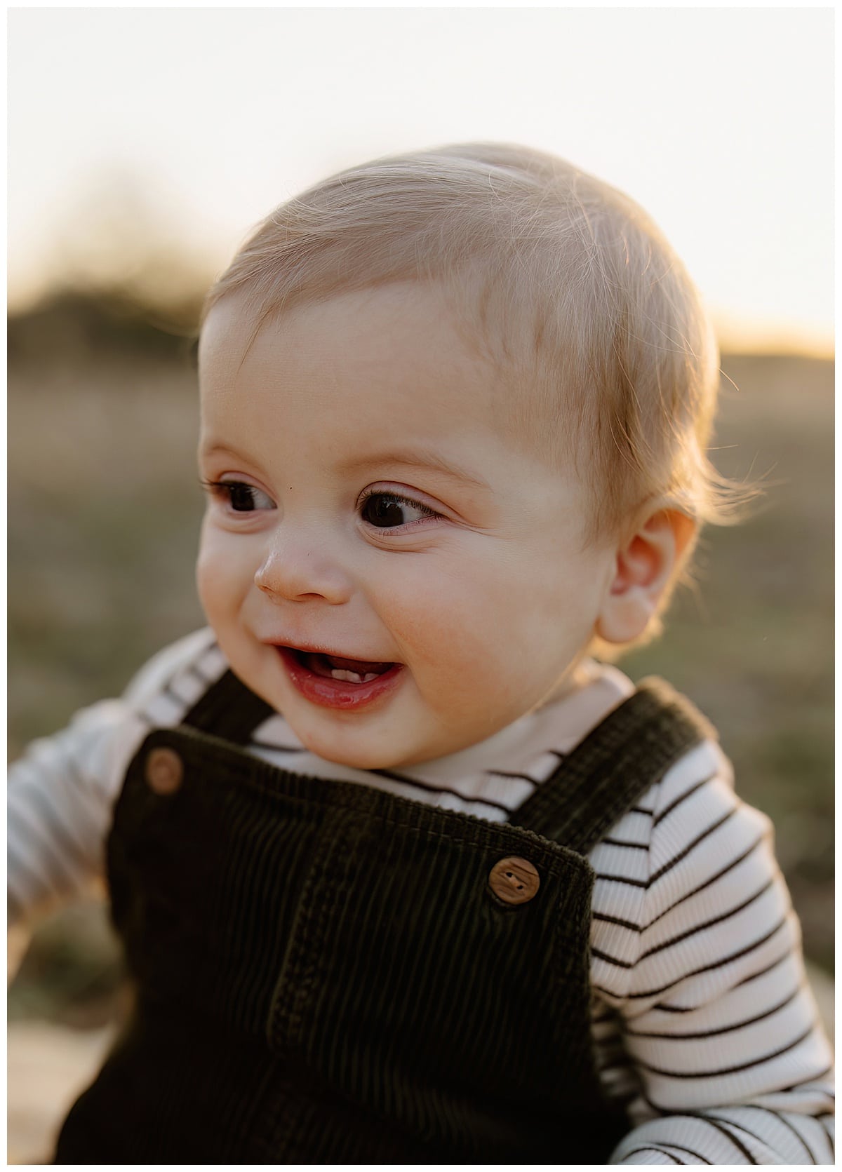 Young baby smiles bug during Winter Family Photos