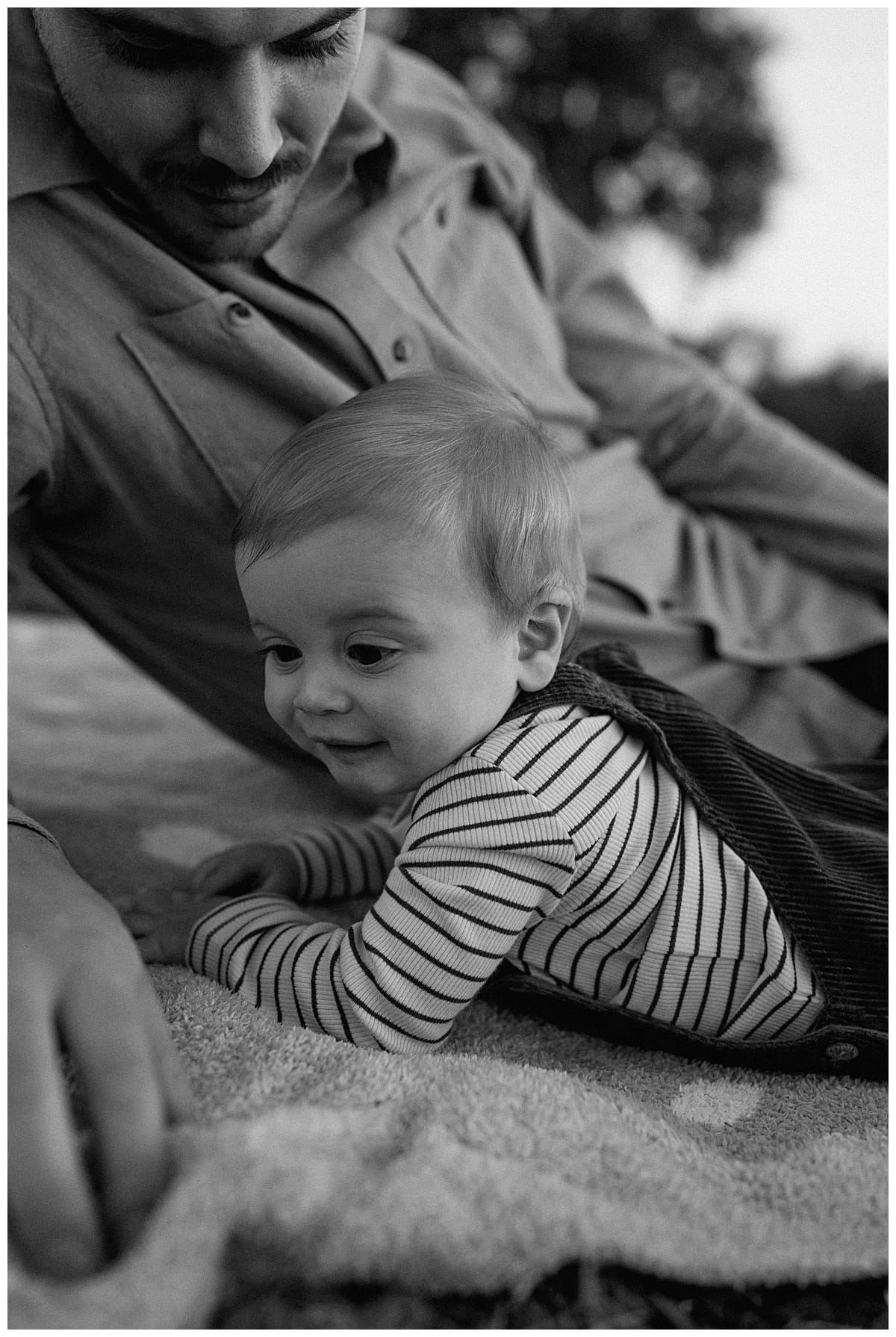 Young baby lays on the floor during Winter Family Photos