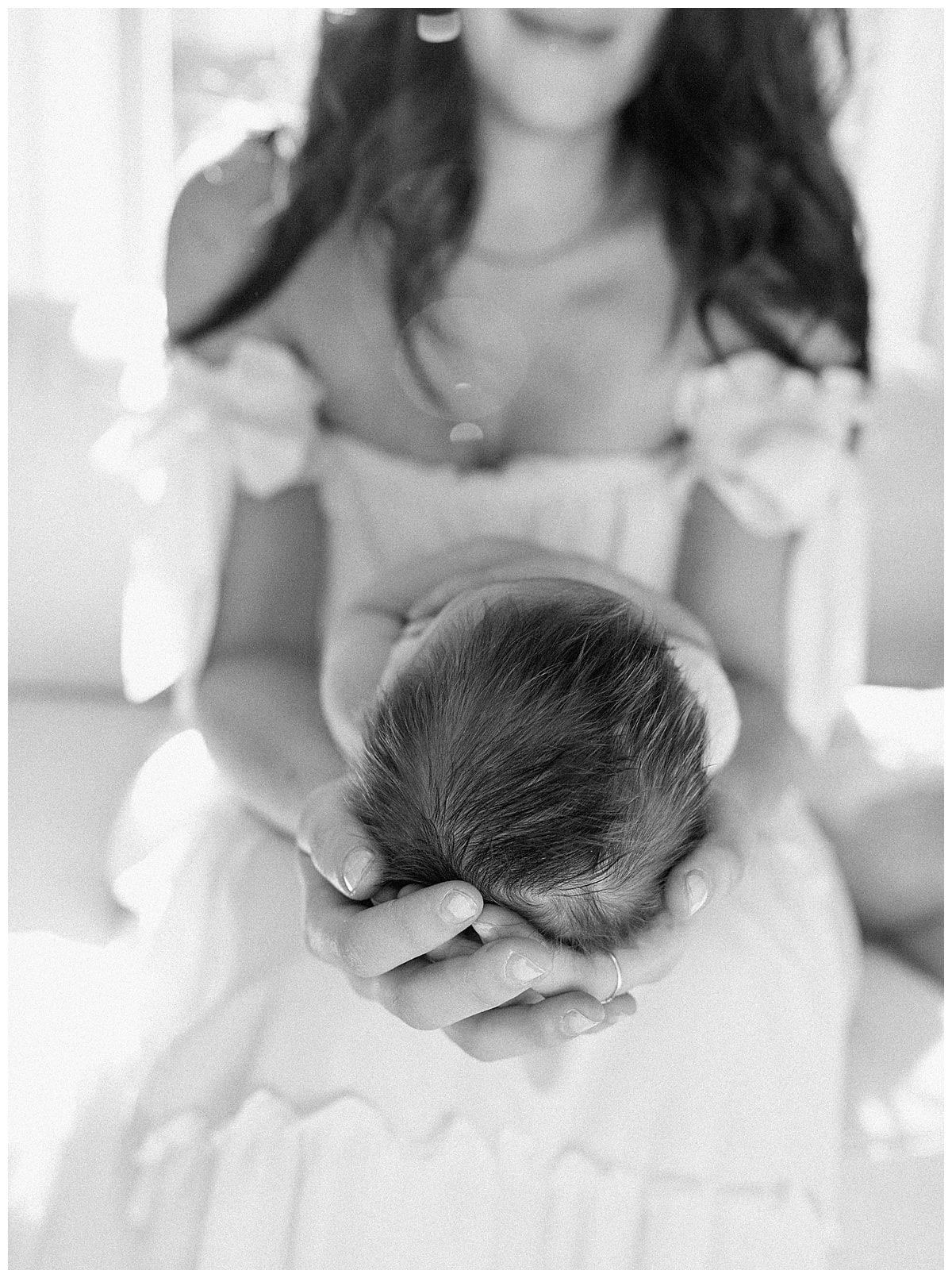 Mom holds young infant for newborn photographer