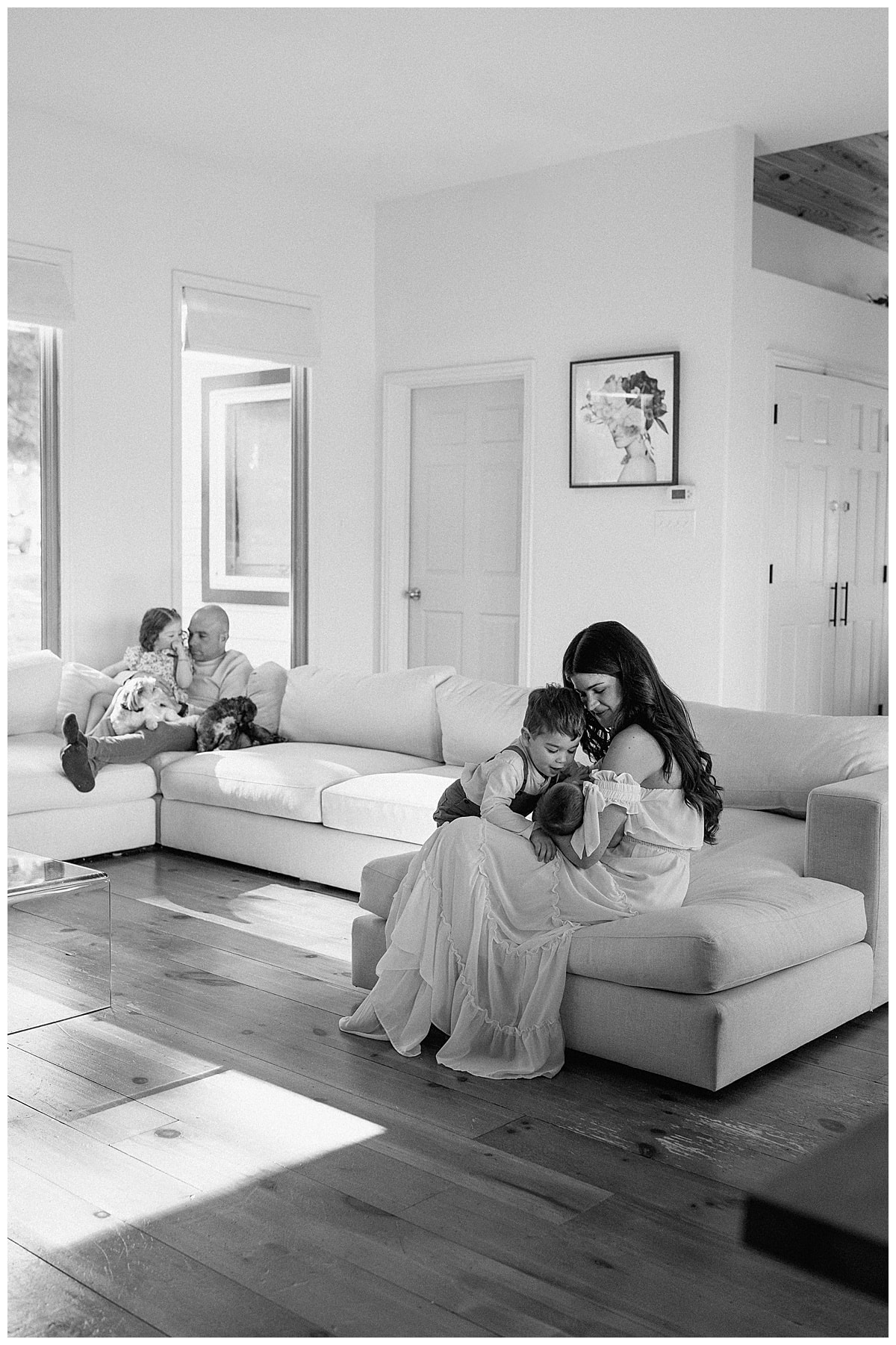 Mom sits with children on the couch for newborn photographer