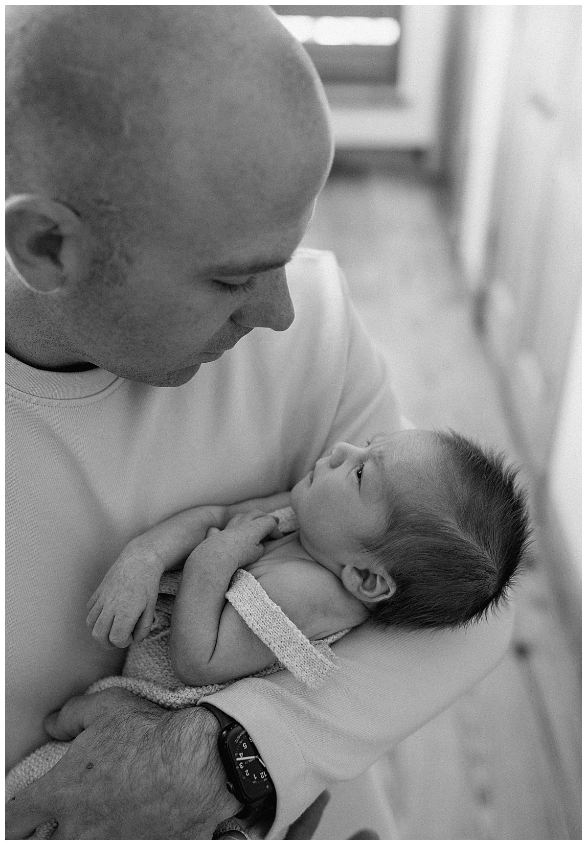 Dad stares at baby for newborn photographer