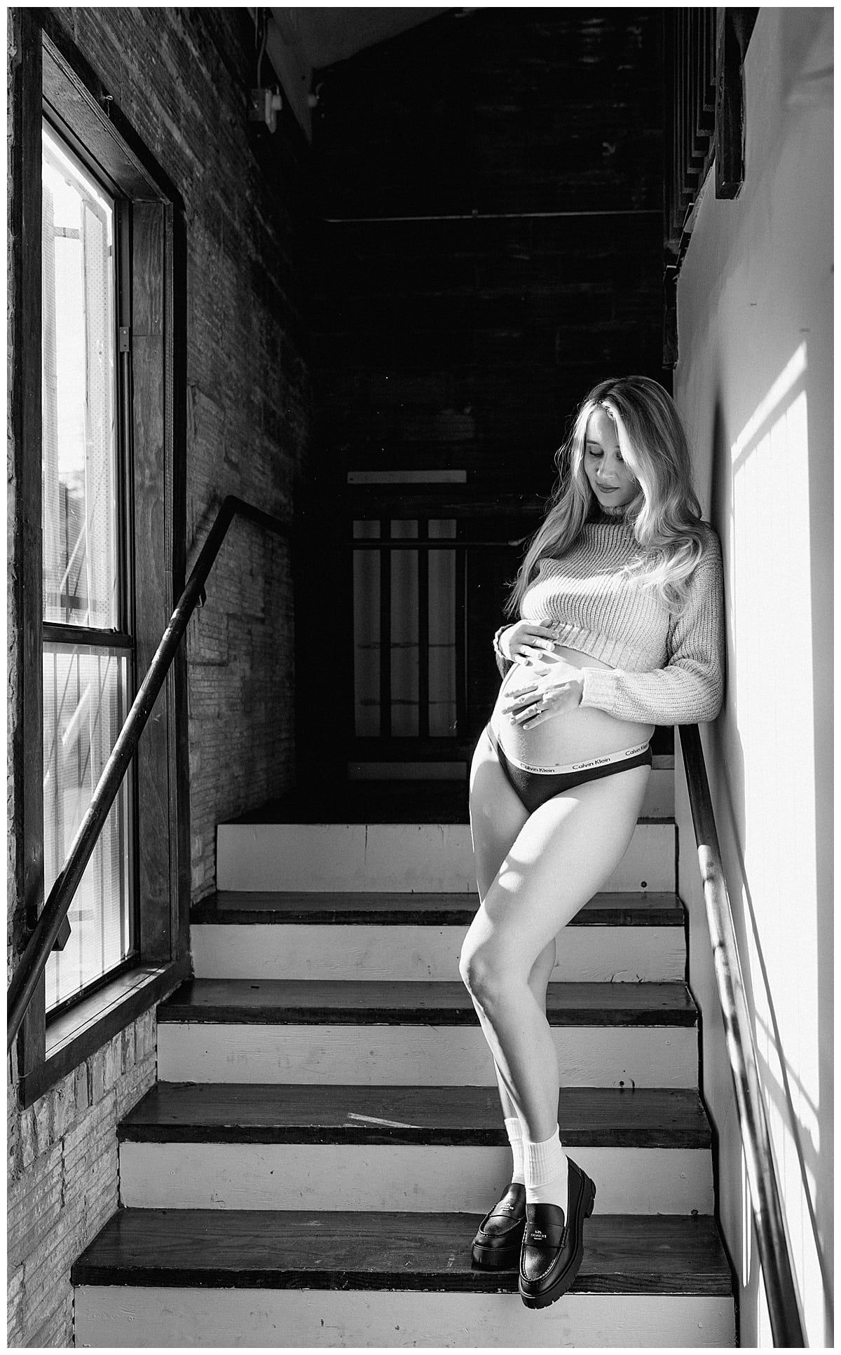 Woman leans against the wall holding her pregnant belly for Our Adventuring Souls Photography
